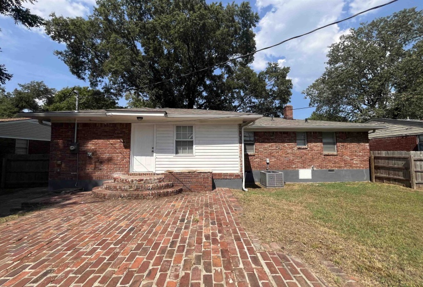 Rear view of house with brick siding, a chimney, and crawl space