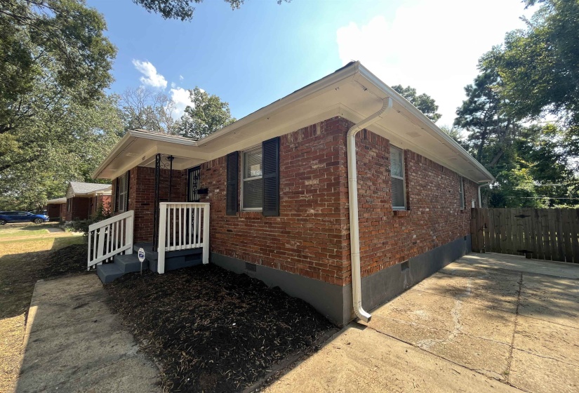 View of side of property with crawl space and brick siding