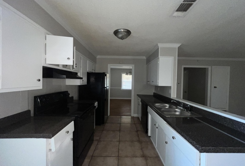 Kitchen featuring black appliances, white cabinetry, crown molding, under cabinet range hood, and light tile patterned floors