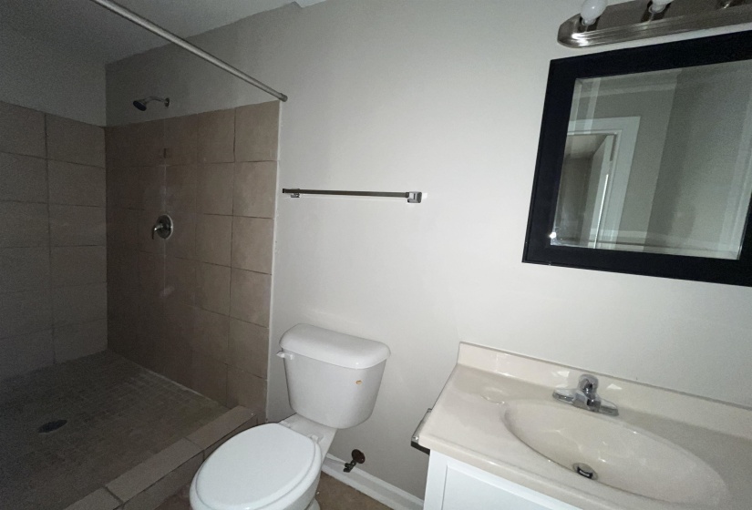 Bathroom with vanity and tiled shower