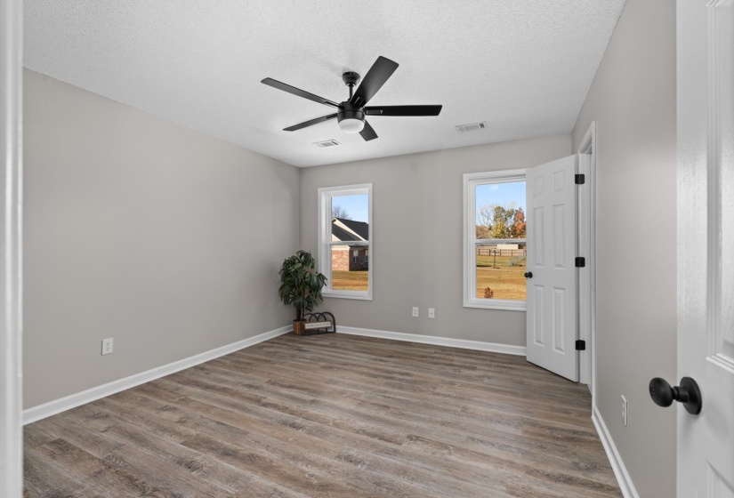 Empty room with light wood-style flooring, a textured ceiling, and a ceiling fan