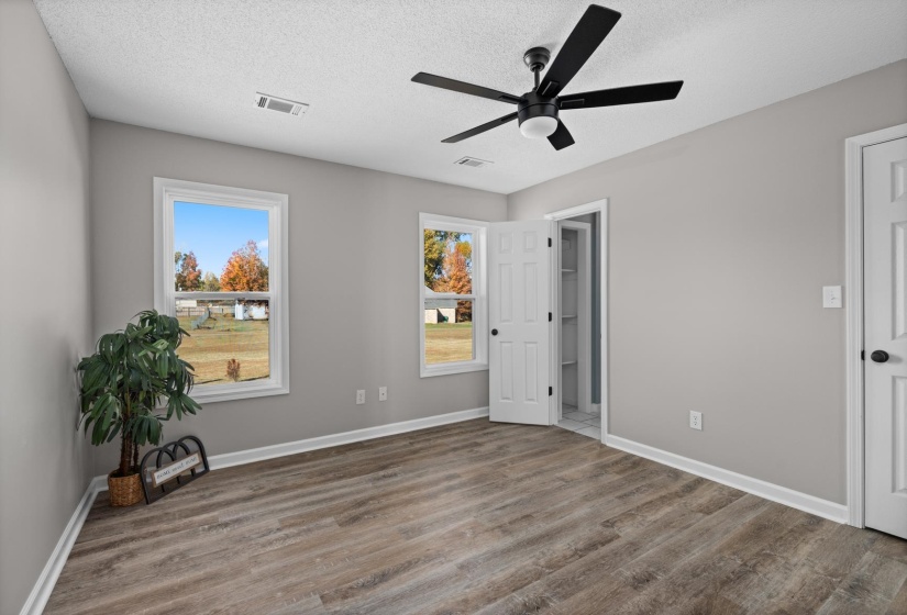 Unfurnished bedroom featuring a ceiling fan, wood finished floors, and a textured ceiling