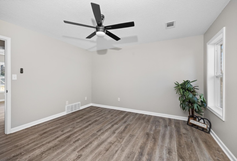 Unfurnished room featuring dark wood-style flooring, a textured ceiling, and ceiling fan