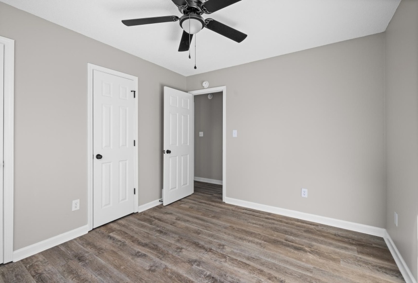 Unfurnished bedroom featuring wood finished floors, a ceiling fan, and a closet