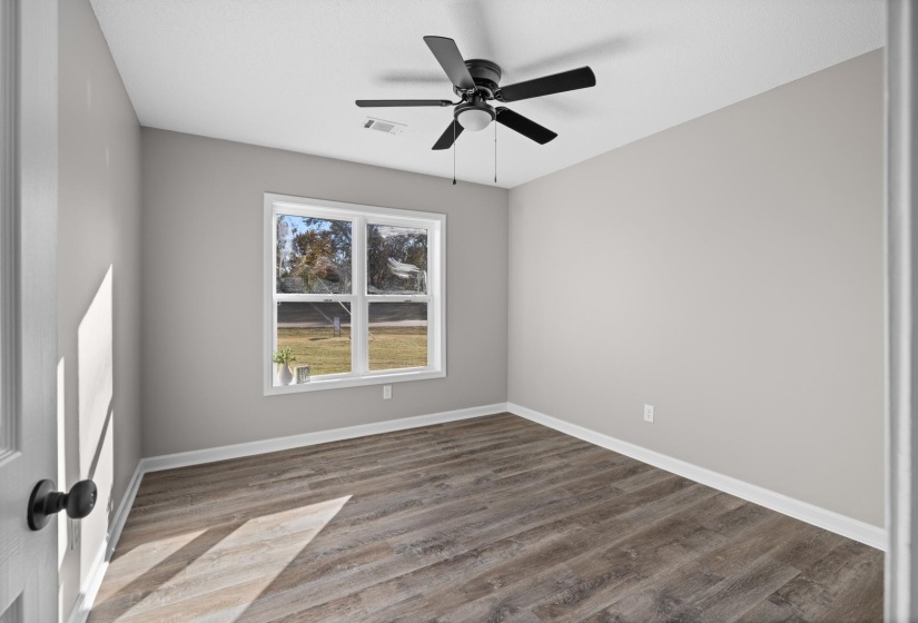 Spare room featuring wood finished floors and a ceiling fan