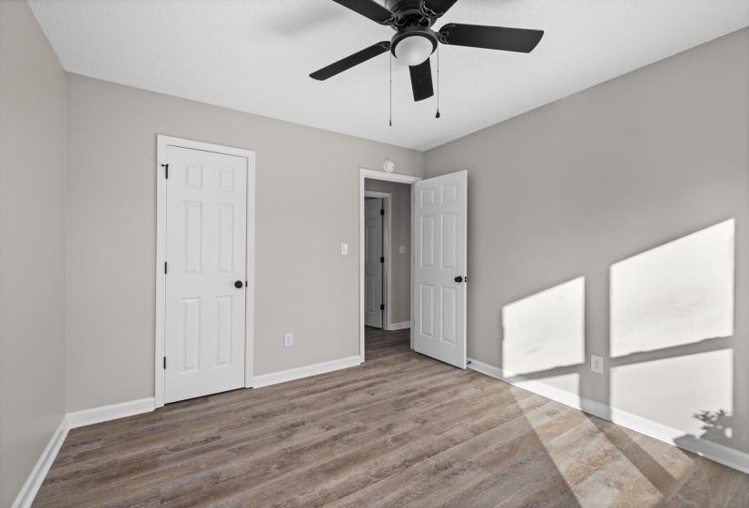 Unfurnished bedroom with wood finished floors, ceiling fan, and a closet