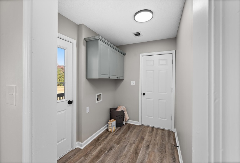 Laundry room featuring dark wood-style flooring, hookup for a washing machine, and cabinet space