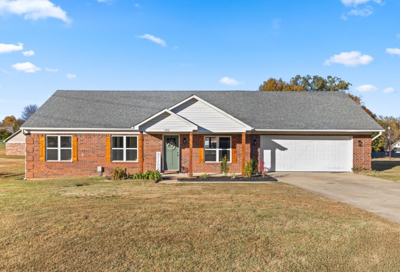Single story home with concrete driveway, roof with shingles, and brick siding