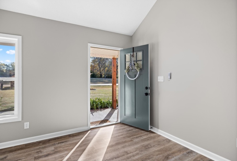 Entrance foyer featuring vaulted ceiling and wood finished floors