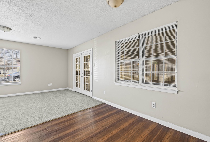 Unfurnished room featuring a textured ceiling, french doors, and wood finished floors