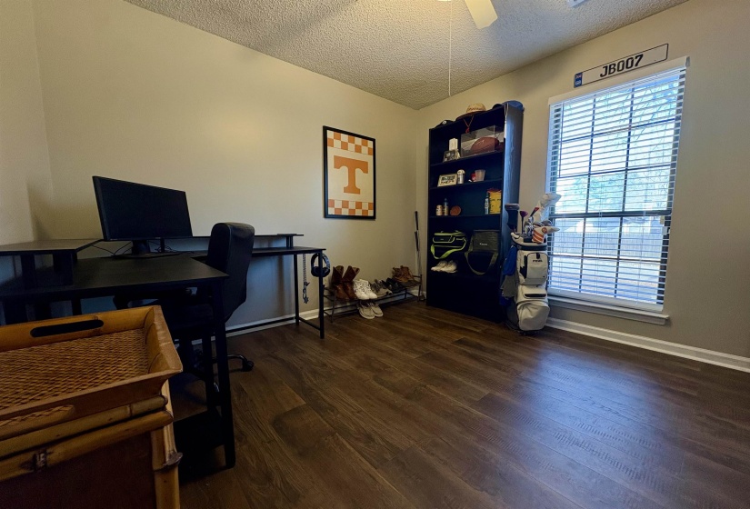 Home office with a textured ceiling, dark wood-style floors, and ceiling fan