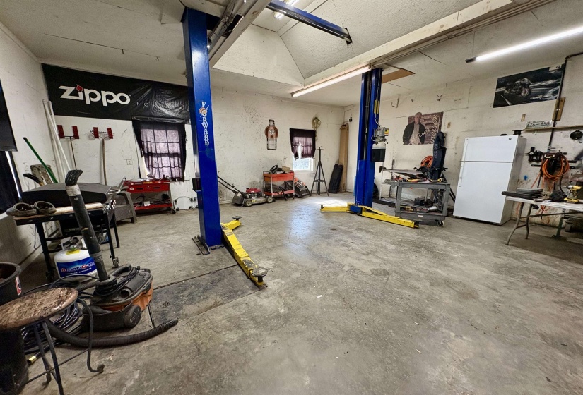 Garage with freestanding refrigerator and a workshop area