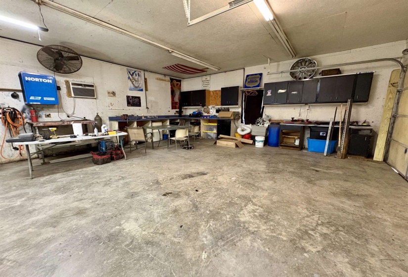 Garage featuring a workshop area and an AC wall unit