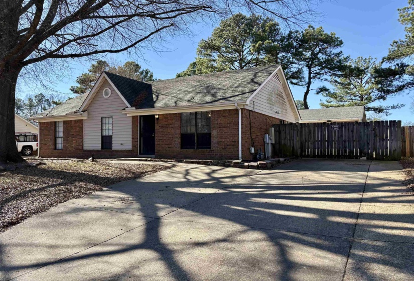 View of front facade with brick siding, a shingled roof, and concrete driveway