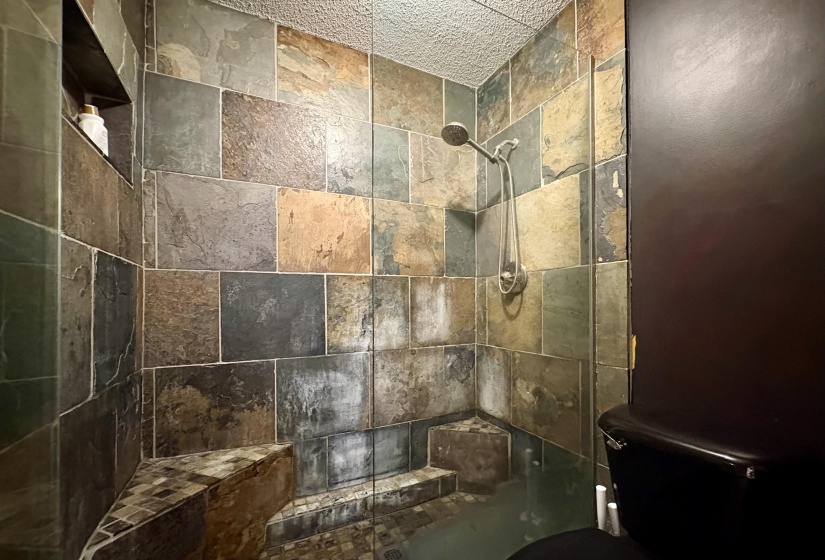 Full bath with a tile shower and toilet