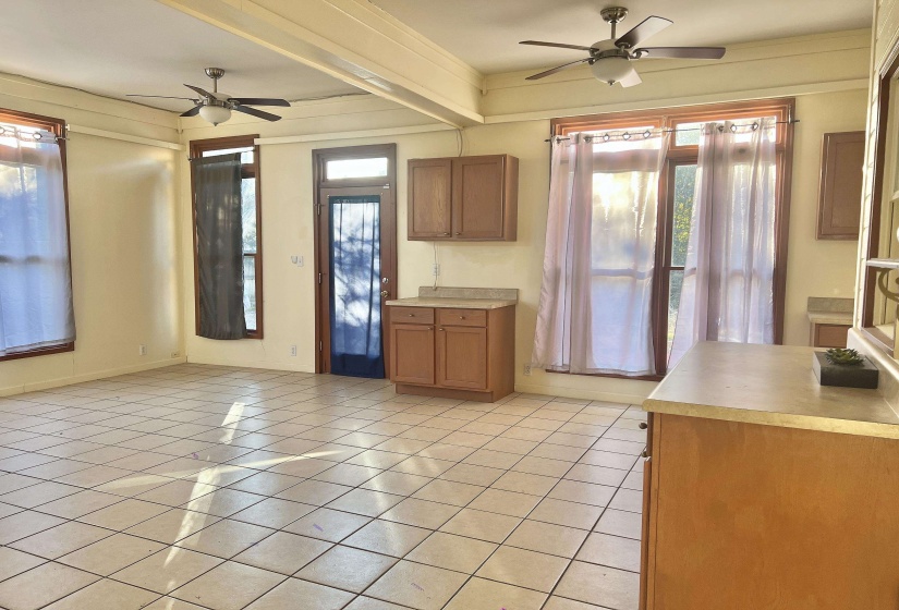 Kitchen with brown cabinetry, ceiling fan, light countertops, and light tile patterned floors