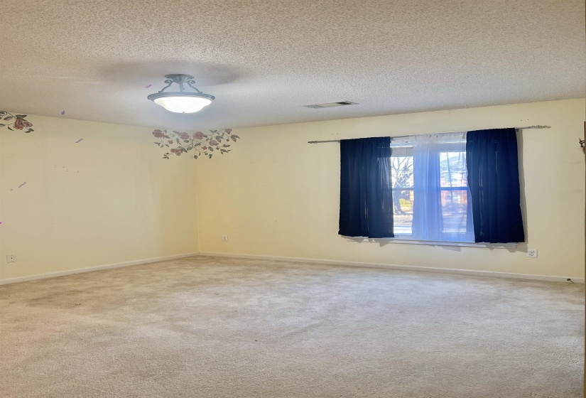 Spare room featuring a textured ceiling and light carpet