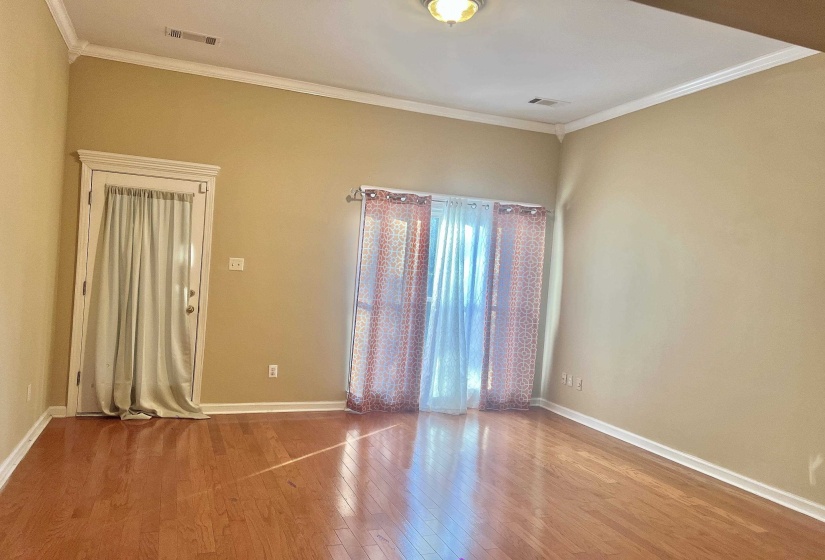 Empty room with wood finished floors and crown molding