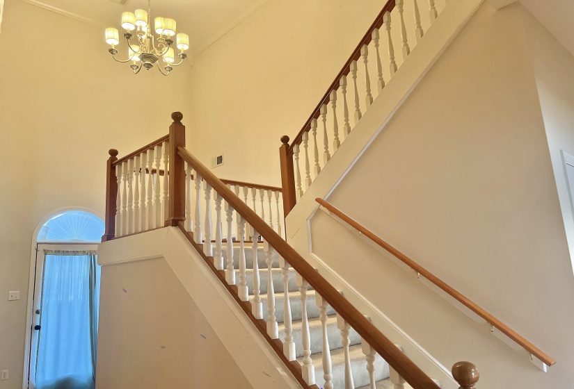 Stairs with a high ceiling and a chandelier