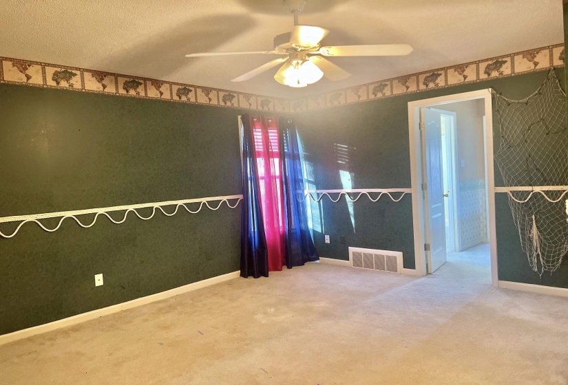 Spare room with ceiling fan, carpet flooring, and a textured ceiling