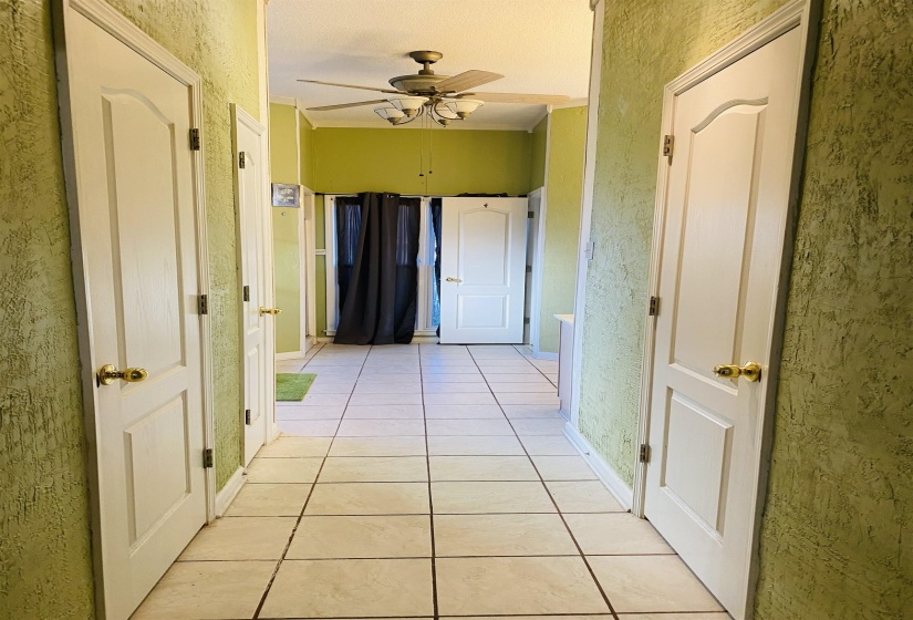 Hallway featuring light tile patterned floors and a textured wall