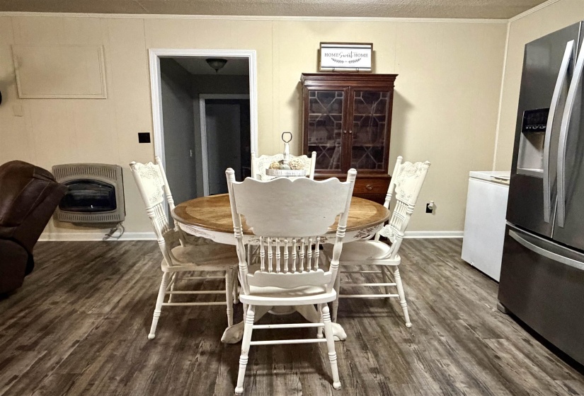 Dining room featuring crown molding, heating unit, and dark wood-type flooring
