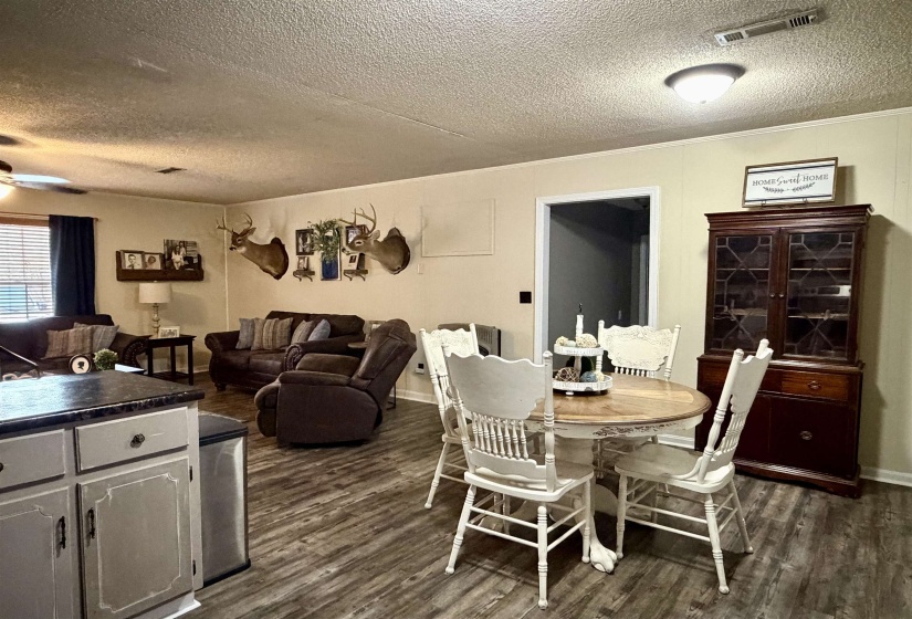 Dining area with a textured ceiling, dark wood-type flooring, and ceiling fan