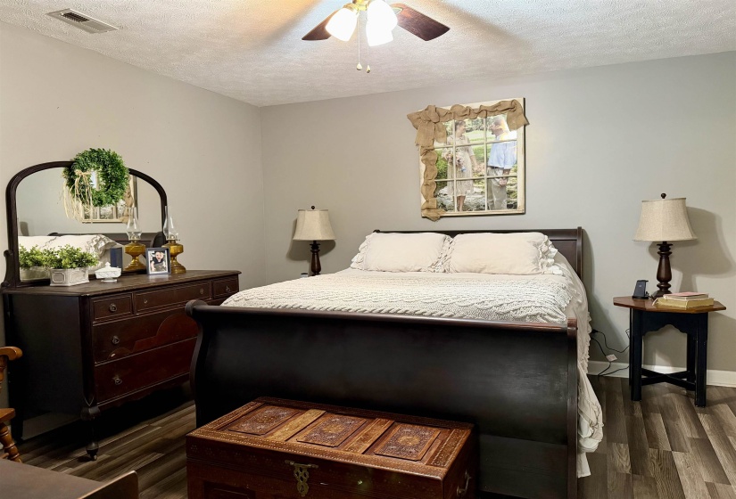Bedroom with a textured ceiling, a ceiling fan, and dark wood finished floors