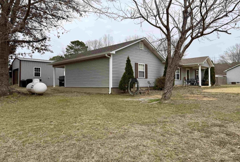 Rear view of property with an outbuilding and a lawn