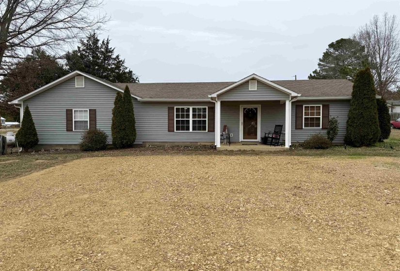 Ranch-style house with a shingled roof and a porch