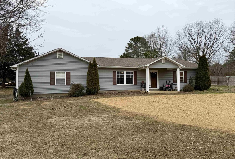 Ranch-style home with a shingled roof and covered porch