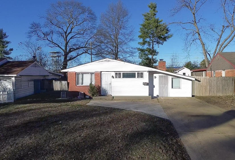 View of front of home featuring a chimney and concrete driveway
