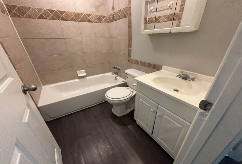Full bath with vanity, dark wood finished floors, and bathtub / shower combination
