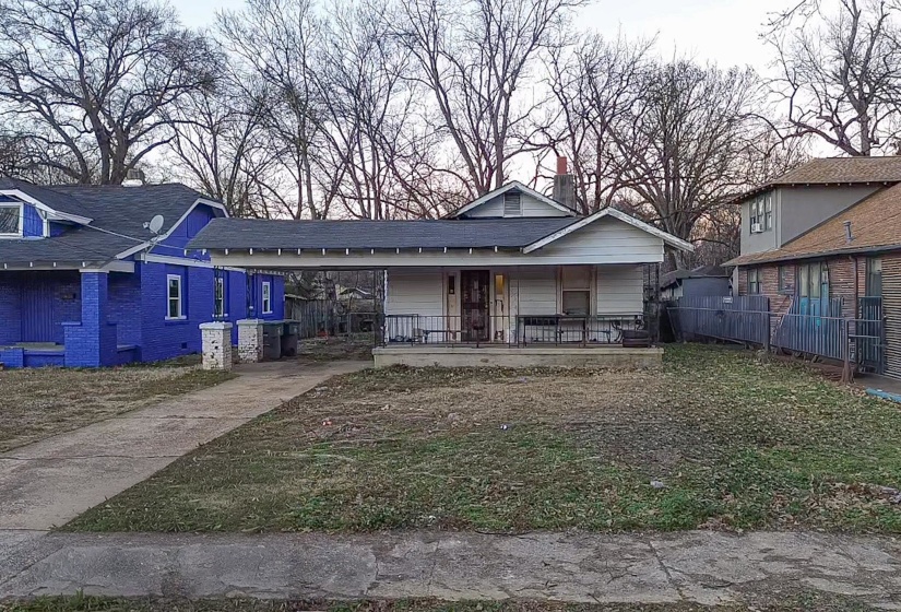 View of front of property featuring covered porch, a carport, driveway, and a shingled roof