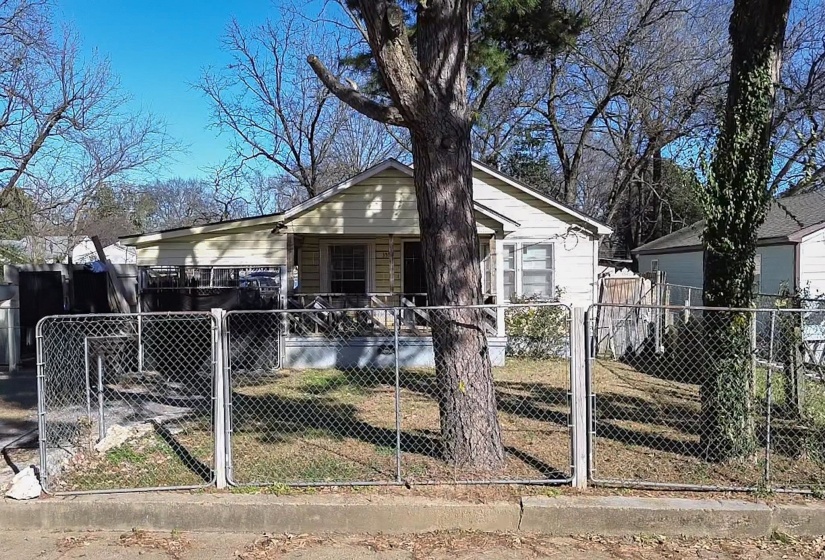Bungalow with a fenced front yard and a gate