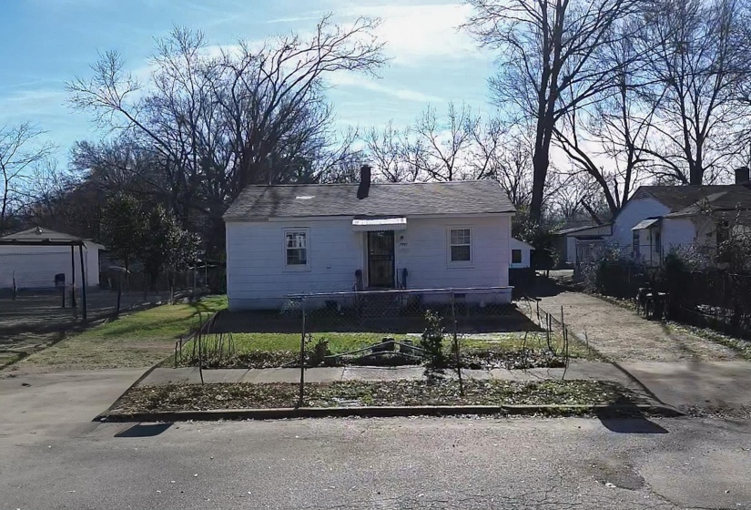 View of front facade with a fenced front yard and a chimney