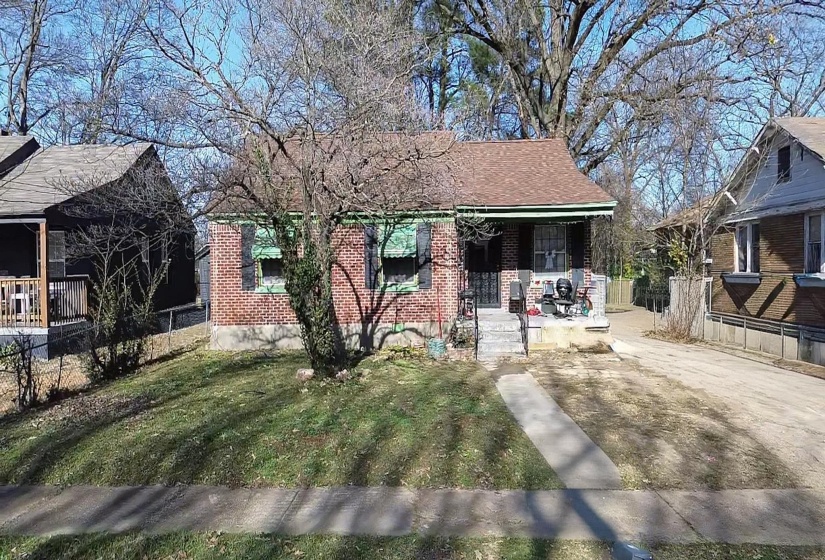 Bungalow-style home with covered porch, brick siding, and roof with shingles