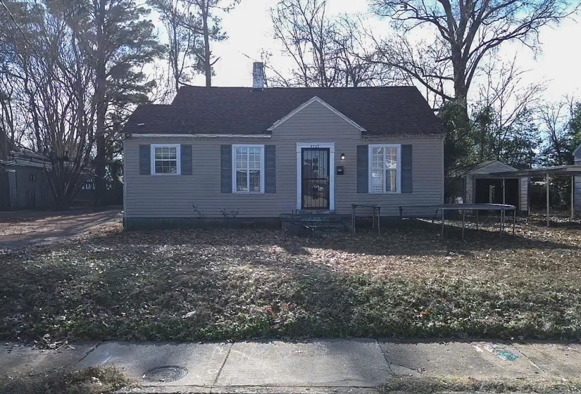 View of front of house with a trampoline, roof with shingles, and a chimney
