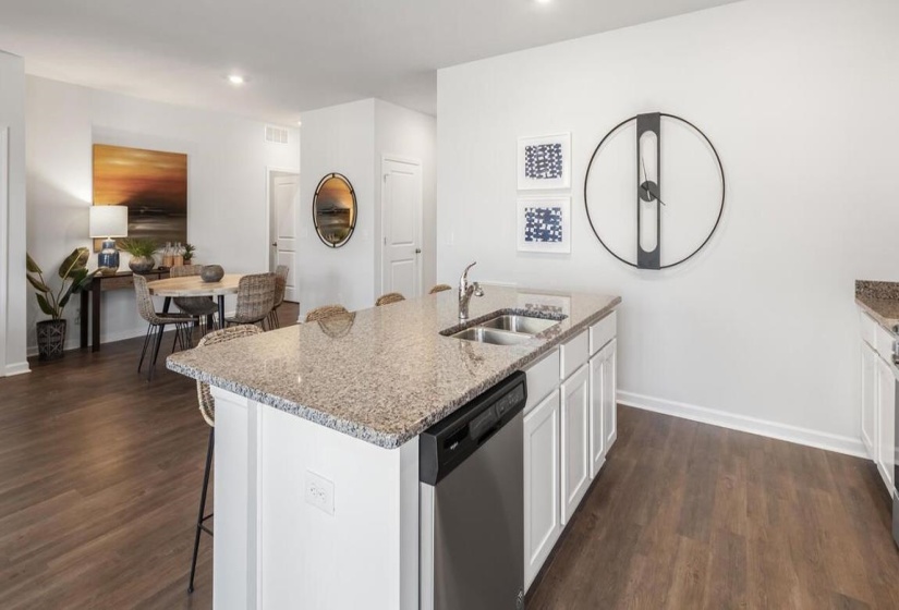 Kitchen with white cabinets, a kitchen bar, dishwasher, dark wood finished floors, and recessed lighting