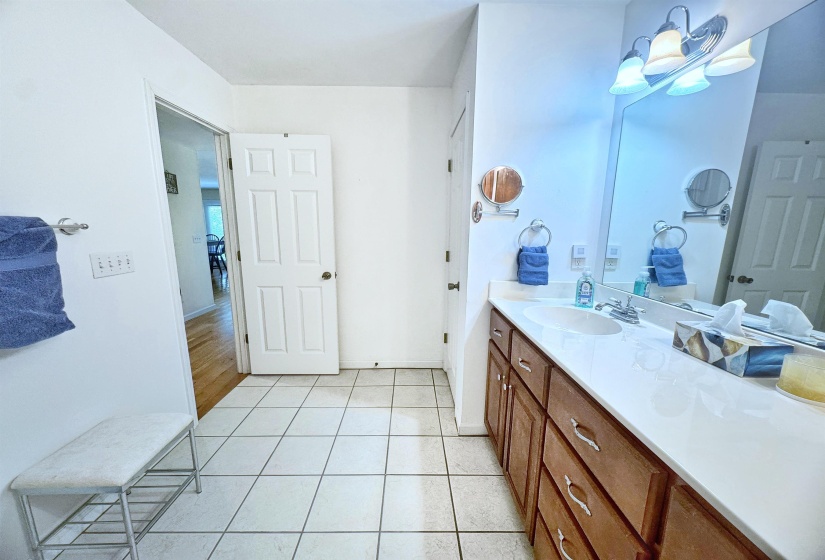 Bathroom featuring a single vanity with wood-finish cabinetry, a white countertop, and an integrated sink