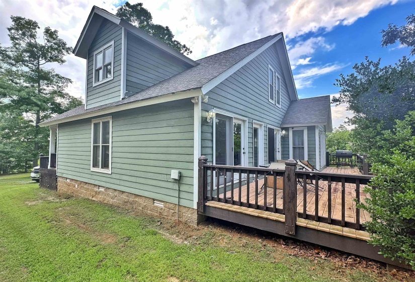 Exterior featuring light green horizontal siding, multiple gabled rooflines, and white trim accents