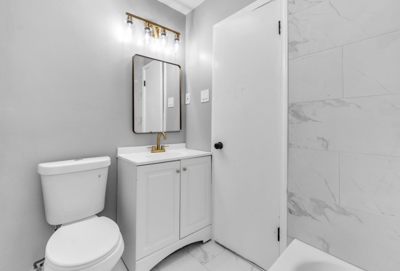 Bathroom with vanity and light marble finish flooring