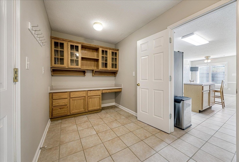 Kitchen with open shelves, light countertops, a textured ceiling, glass insert cabinets, and light tile patterned flooring
