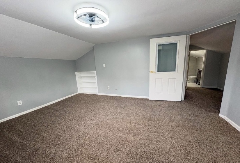 Bonus room featuring vaulted ceiling, carpet floors, and built in features