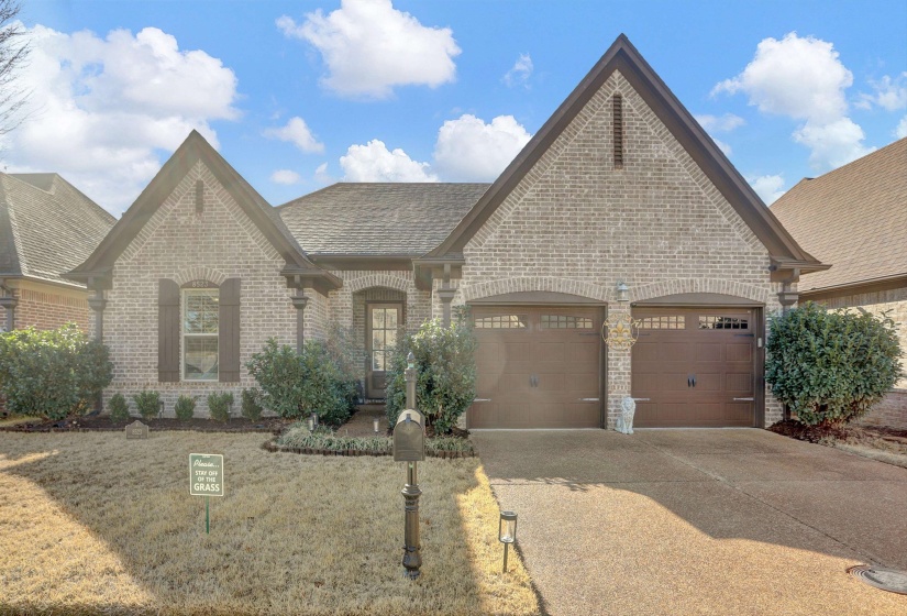 French country style house with brick siding, concrete driveway, an attached garage, and a shingled roof