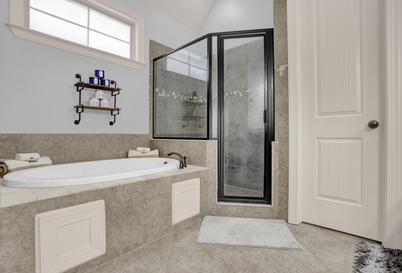 Full bathroom featuring a garden tub, a stall shower, and tile patterned flooring