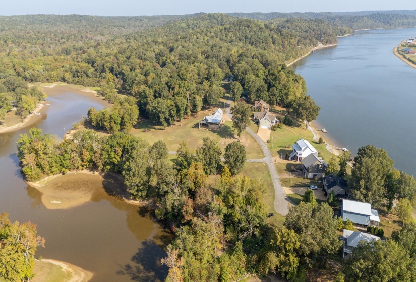 Aerial view of property's location with a large body of water and a heavily wooded area