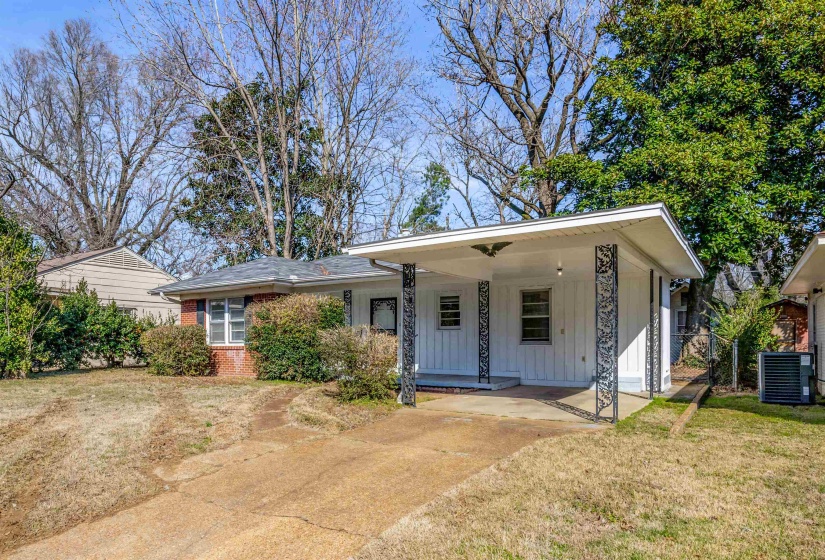 View of front of house with a carport, a porch, board and batten siding, concrete driveway, and brick siding