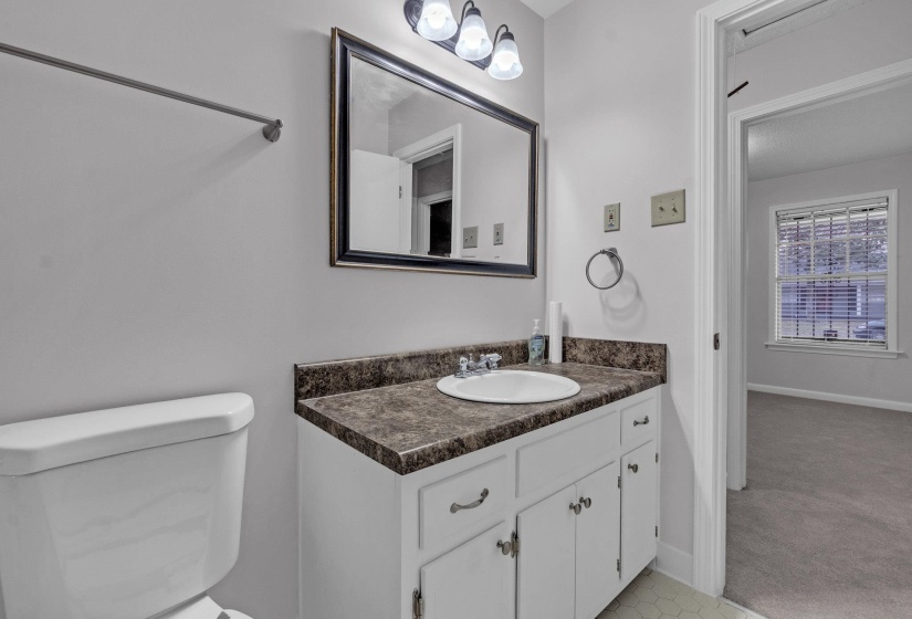 Half bathroom with vanity and light carpet