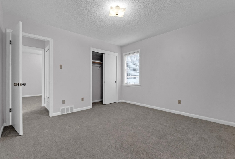 Unfurnished bedroom featuring light carpet, a closet, and a textured ceiling
